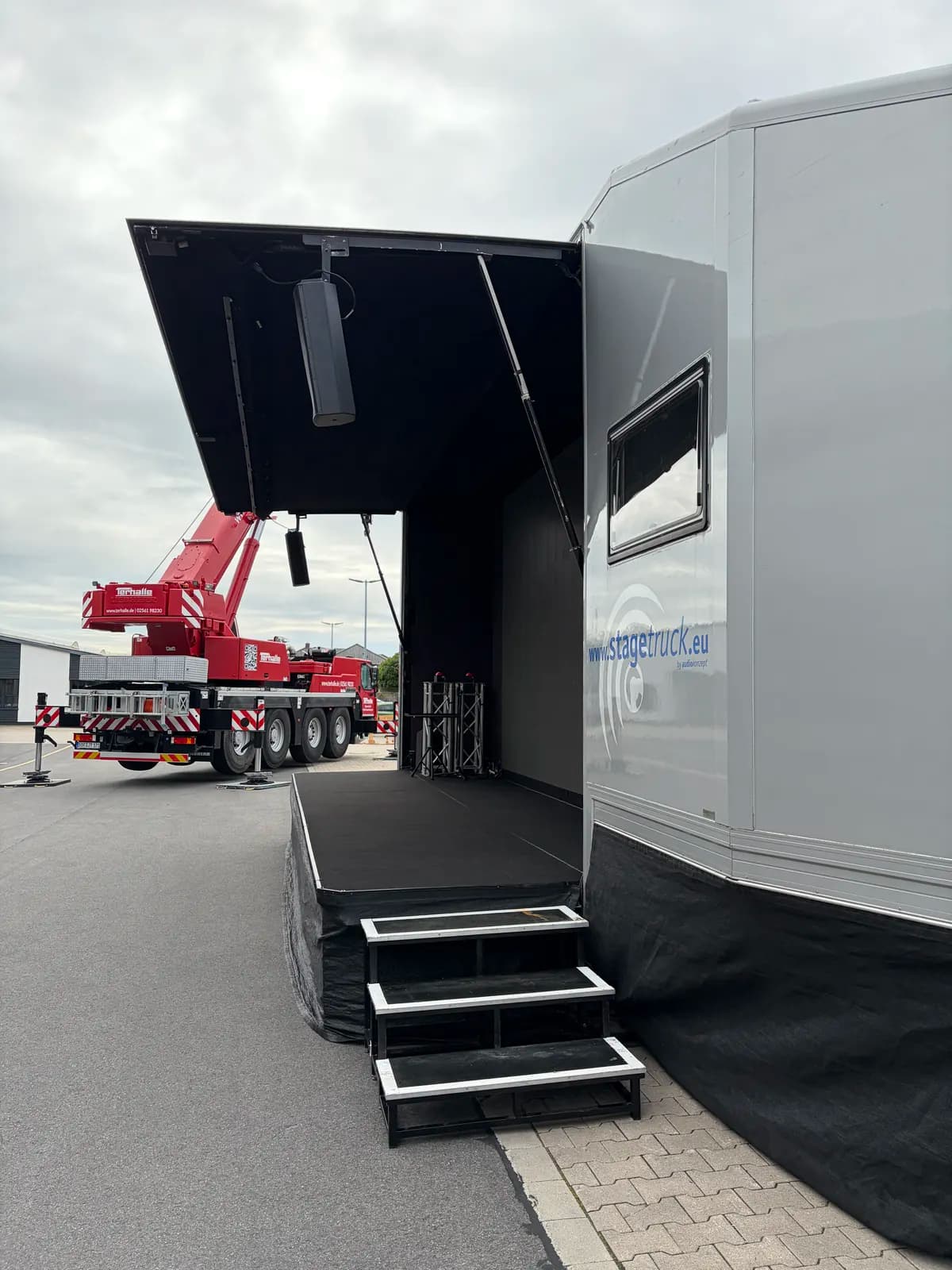 Seitenansicht des geöffneten stagetruck mit hochgefahrenem Bühnendach und Treppenaufgang zur Bühnenfläche